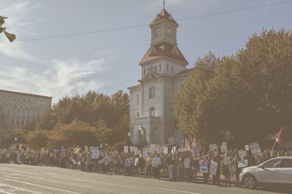 Protestesters holding signs and standing in fron of the Benton County Courthouse. 